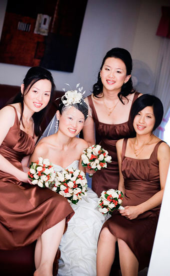 Asian bride with her bridesmaid holding bouquets