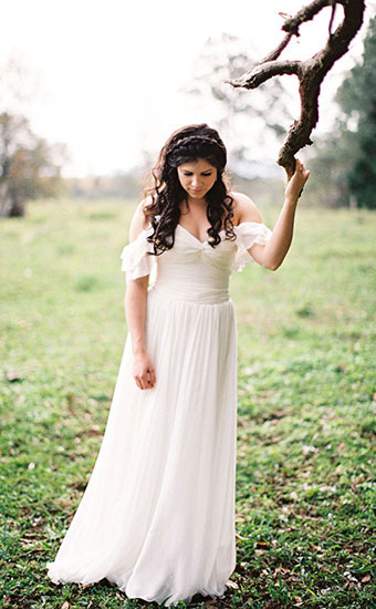 Full body shot of a curly hair bride outdoors