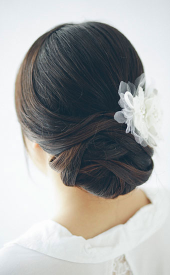 Weaved wedding hairstyles with a white cloth rose